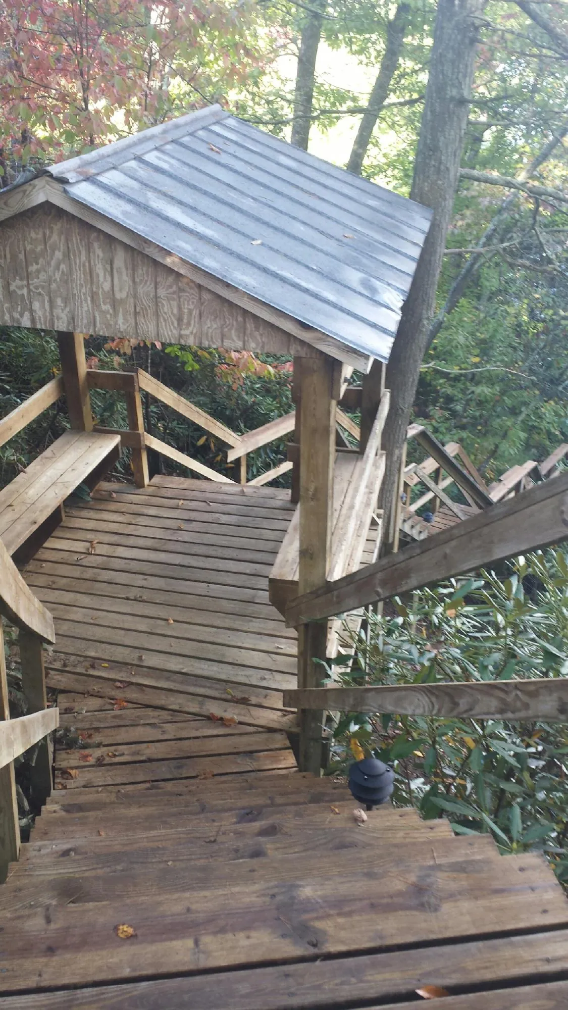 Metal roofed shelter over wooden steps on a wooded walkway — Skylight Repair & Installation work by our crew in Key Biscayne